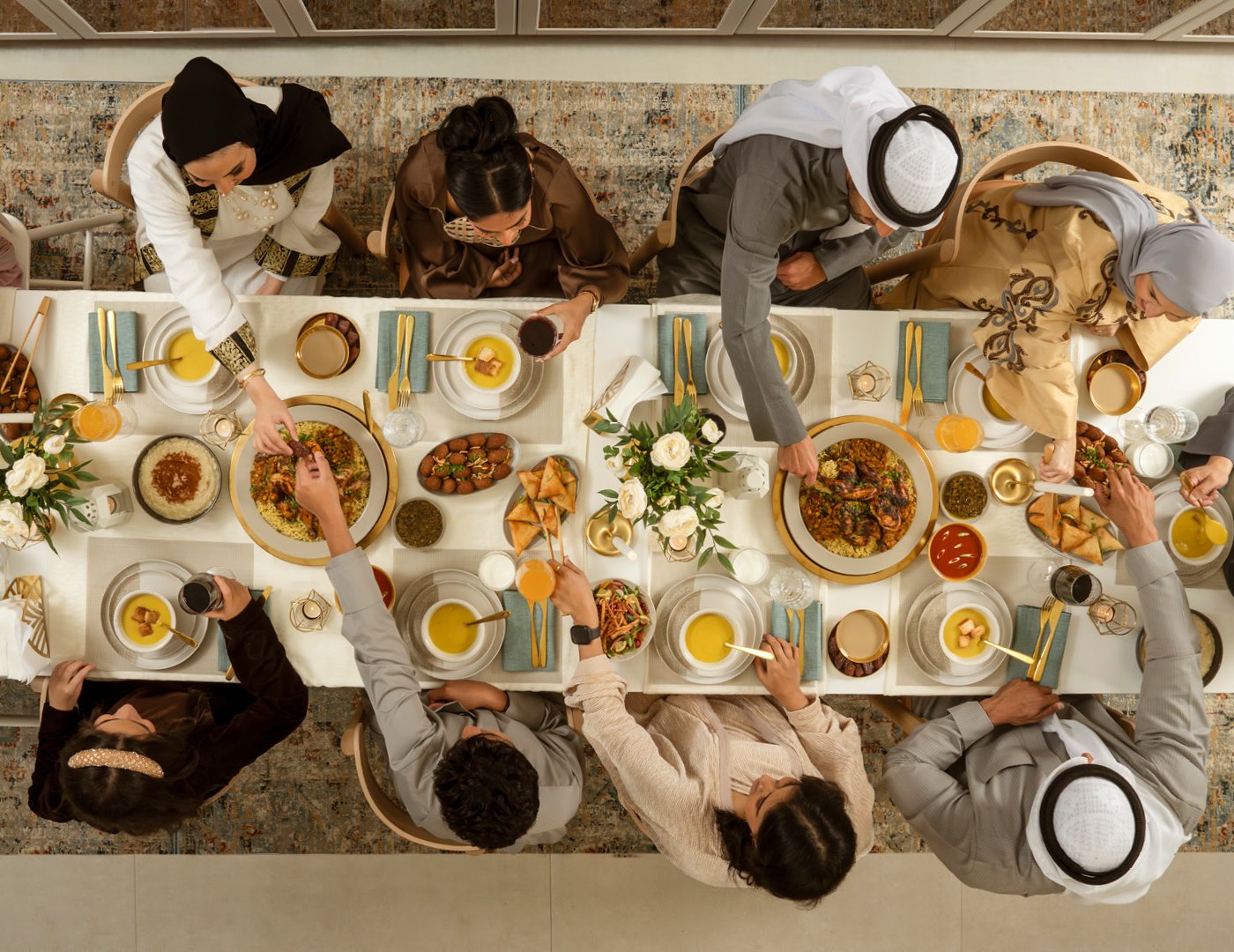 family gathers: grandparents, parents and children over a traditional kuwaiti meal