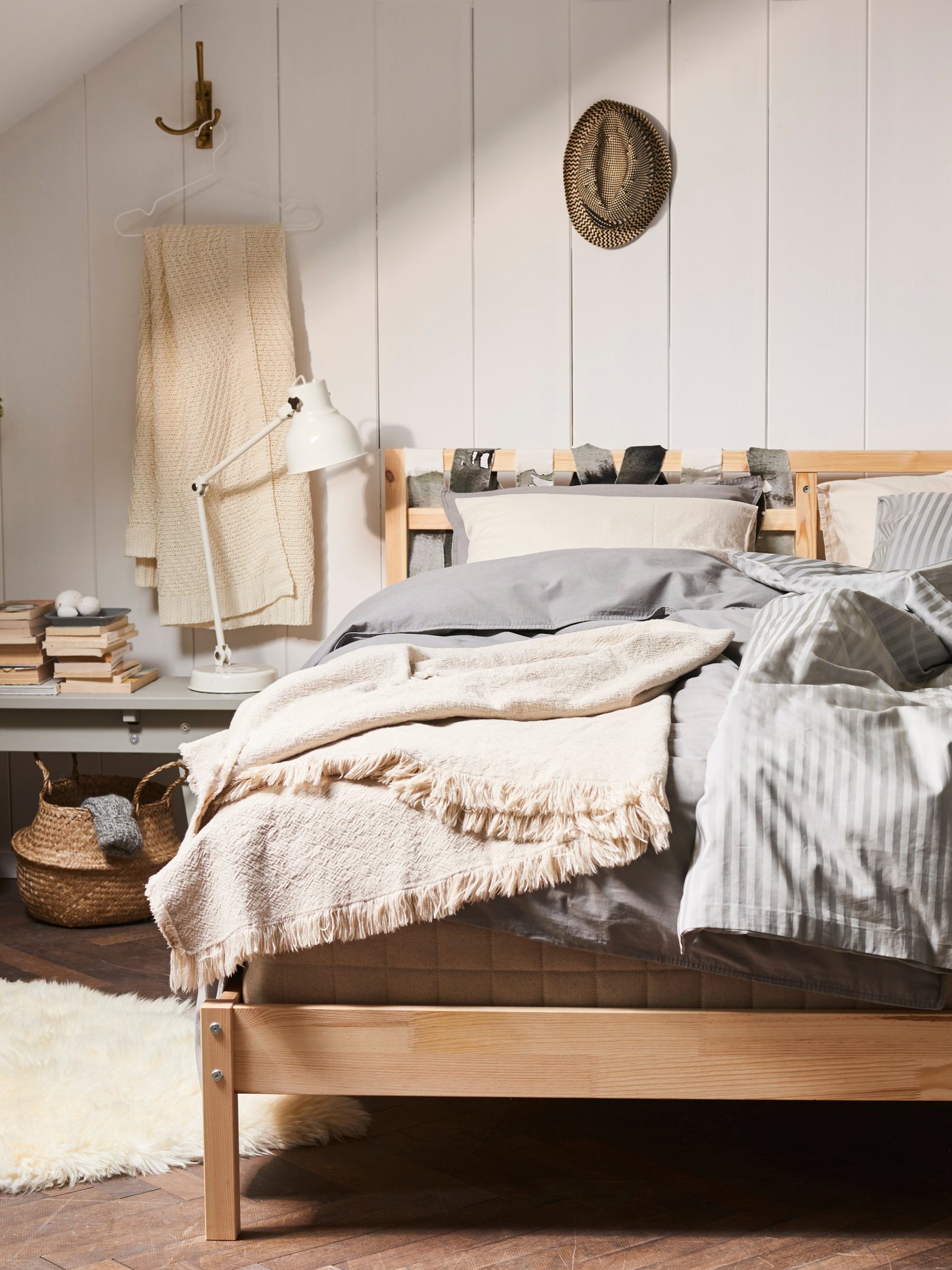 Ein Bett mit Kissen, Decken und Überwürfen im Scandi-Boho-Stil