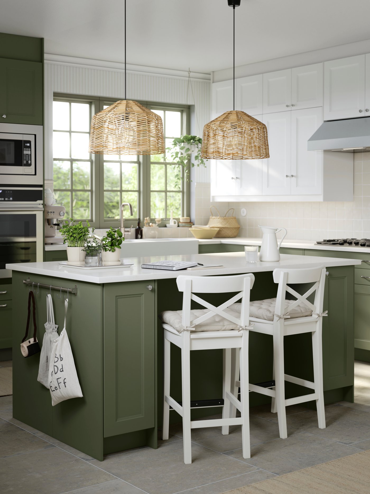 A kitchen with base cabinets with grey-green AXSTAD fronts and wall cabinets with white AXSTAD fronts has a kitchen island.