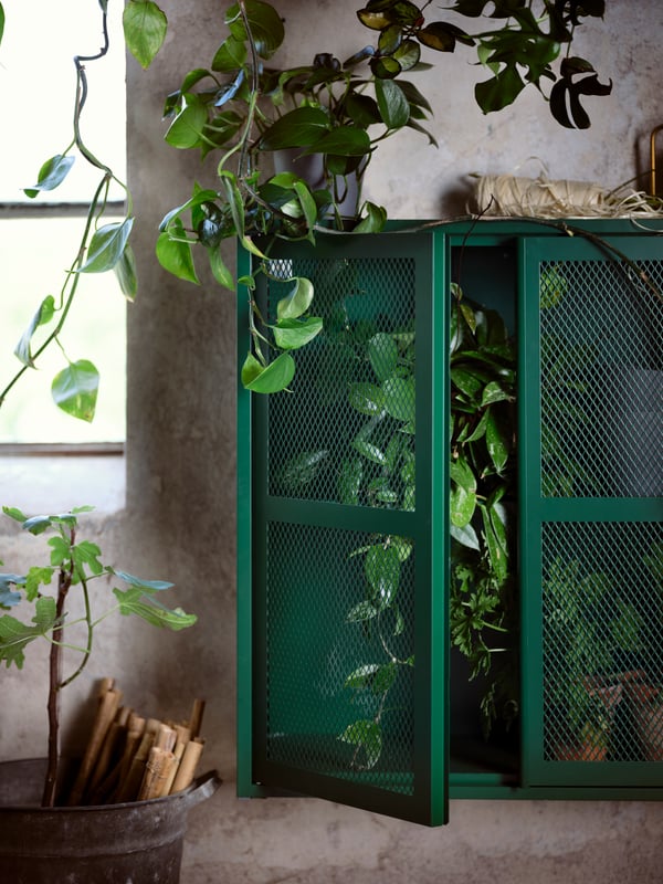 A grey-green mesh IVAR cabinet with doors in the living room