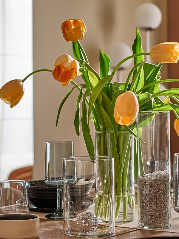 IKEA CYLINDER set of three glass vases on a dining table with a clear glass STORSINT glass in the dining room