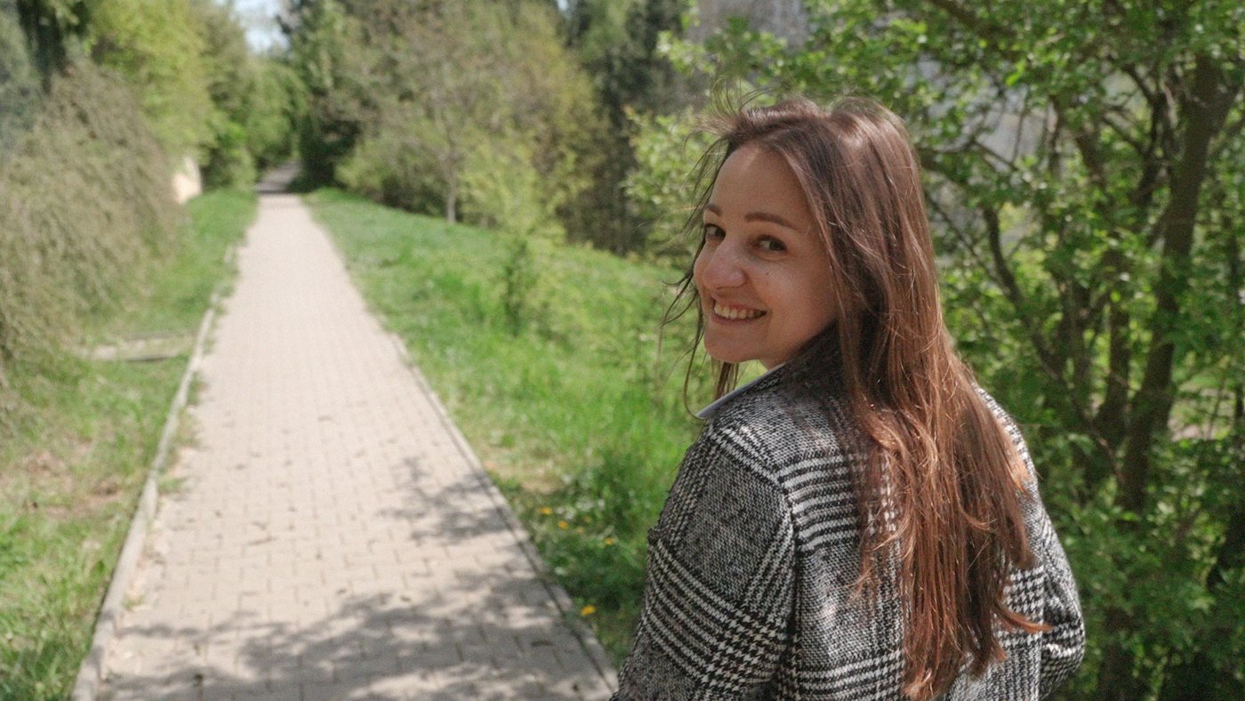 girl called natalia looking into camera while walking in a meadow smiling