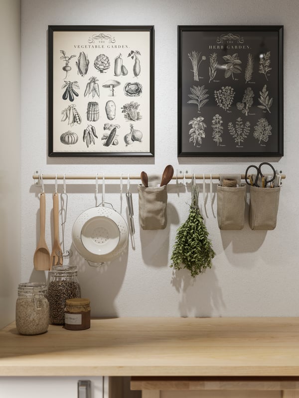 Imágenes de cocina con marcos de foto negro KNOPPÄNG sobre barra con utensilios de cocina.