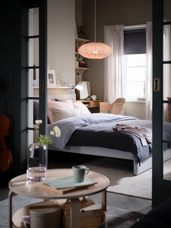 Dormitorio con cama GLADSTAD junto a una ventana.