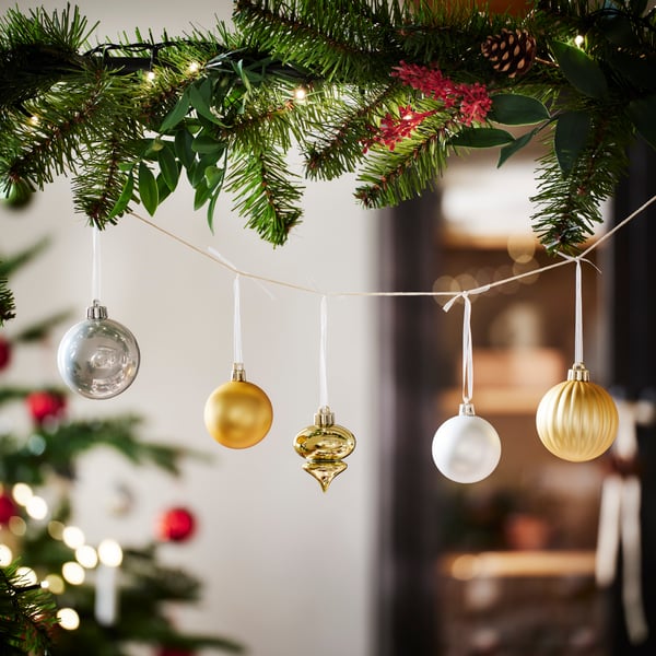 Hanging Christmas ornaments displayed on evergreen branches