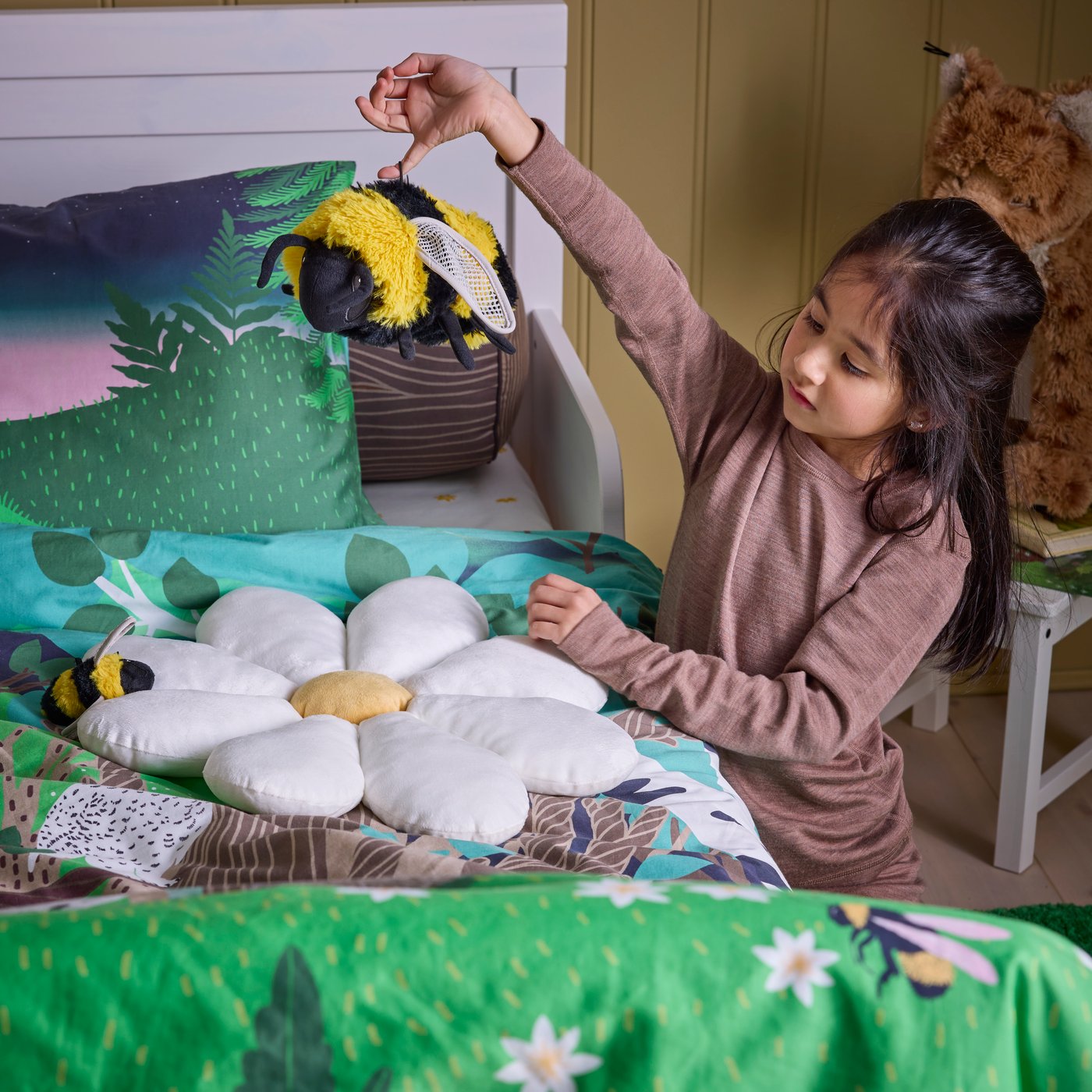 A bumblebee/black yellow SKOGSDUVA soft toy in the childrens room