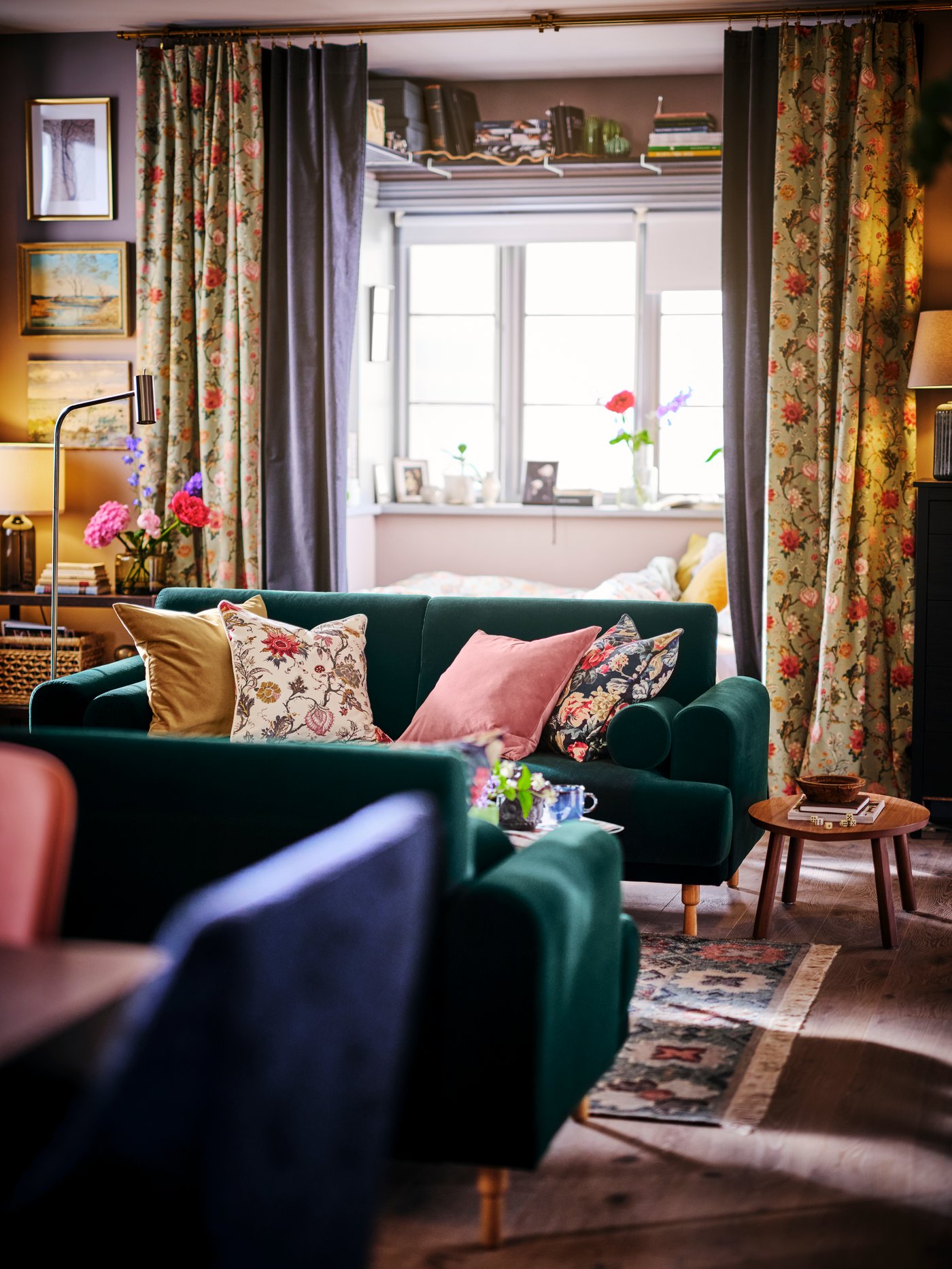 Two dark green LÅNGARYD sofas facing one another, with STOCKHOLM nesting tables to the side and a bay window behind.