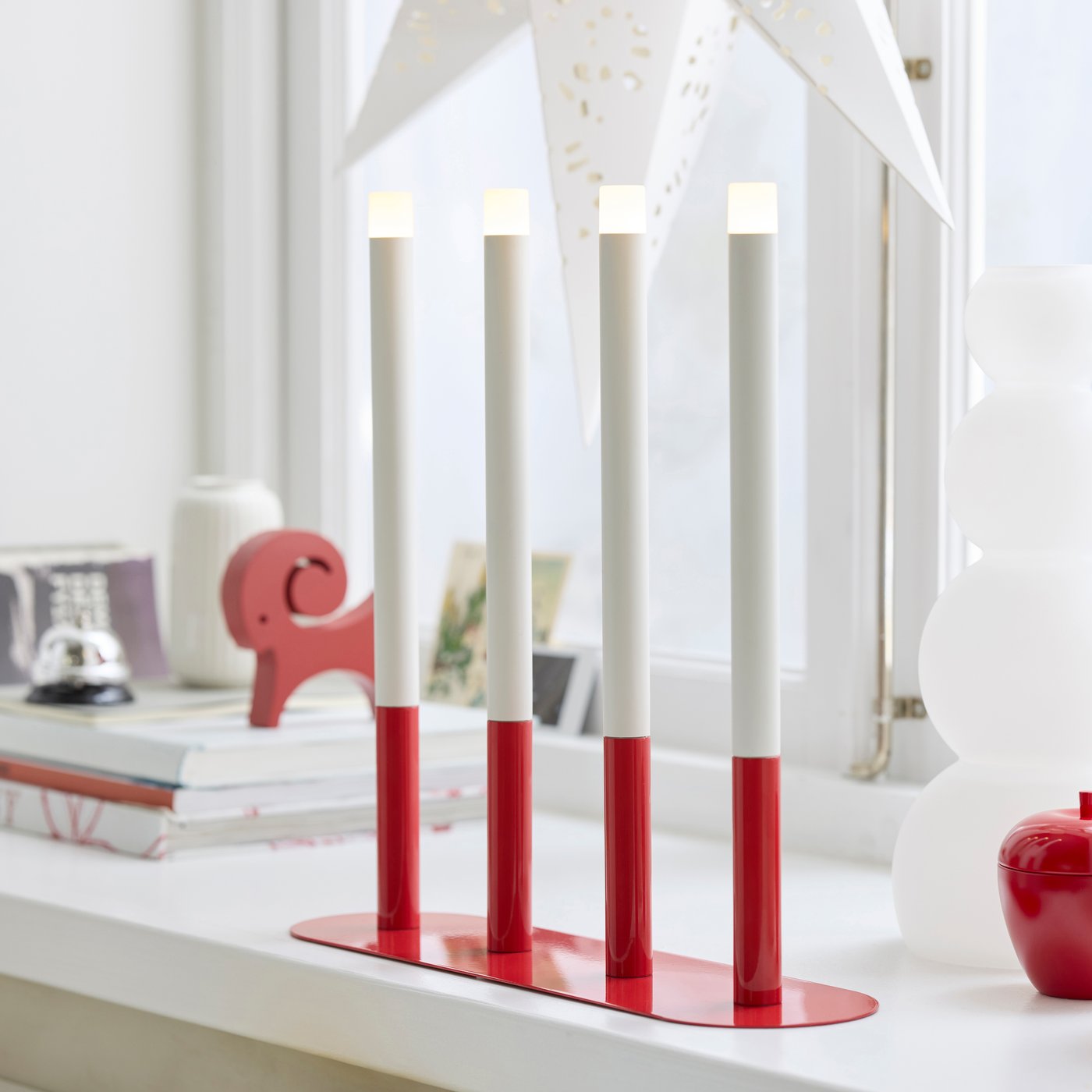 A candle-shaped battery-operated/red STRÅLA LED candelabra