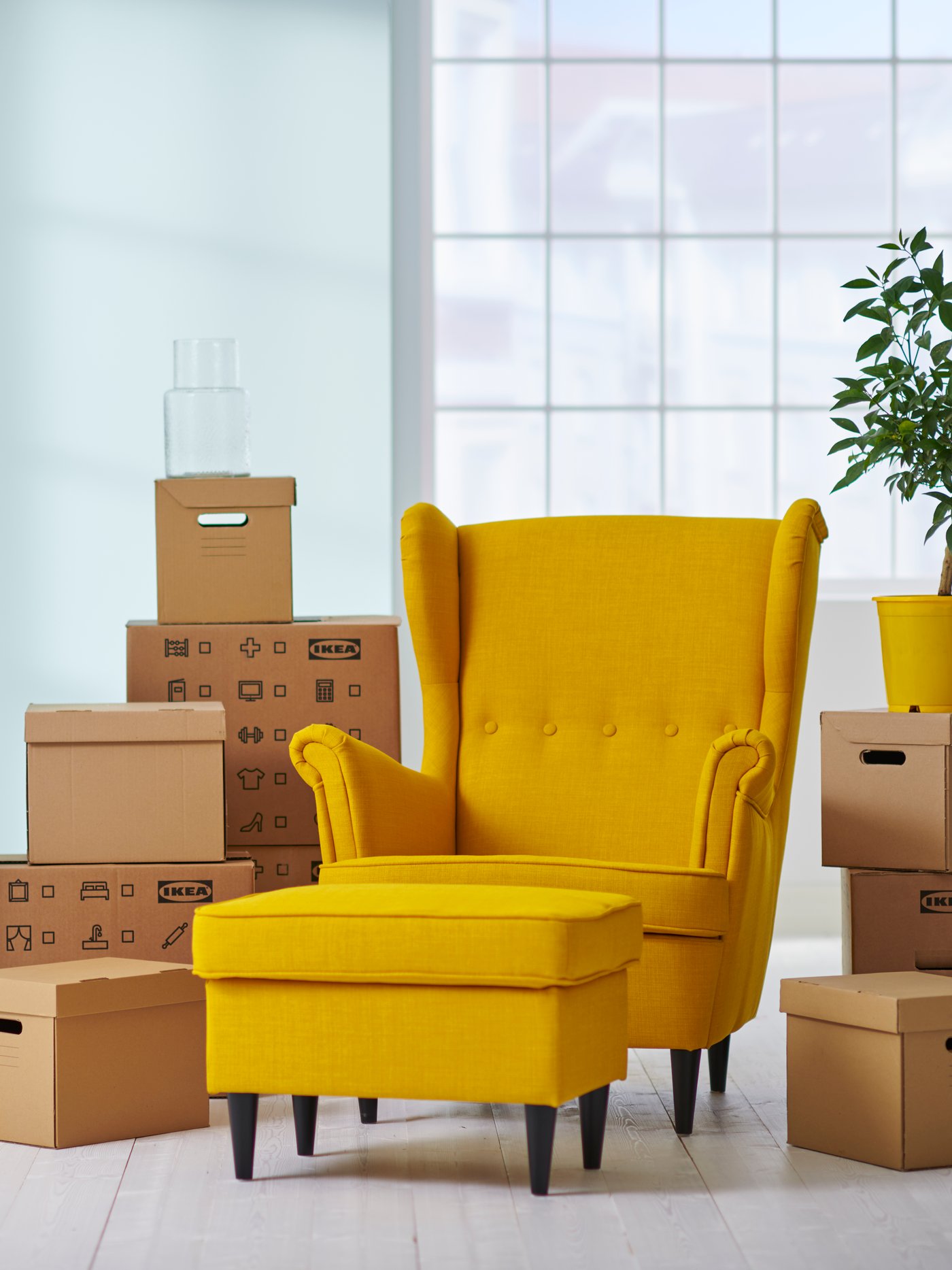 yellow POANG with cardboard boxes stacked around