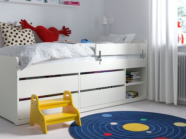 White kids storage bed with four drawers and an open shelf area in a kids room