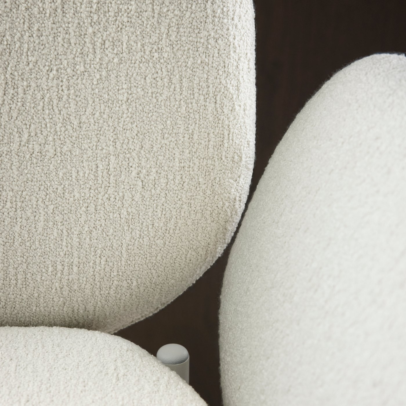 A close-up of a SYNTORP bar stool with backrest showing one armrest and the backrest with their off-white covers.