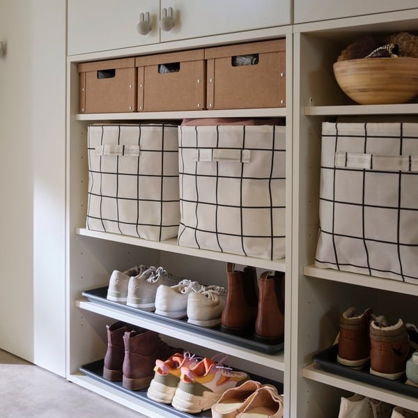 A wardrobe combination with BAGGMUCK shoe mats placed on shelves to hold multiple pairs of shoes beneath storage baskets.