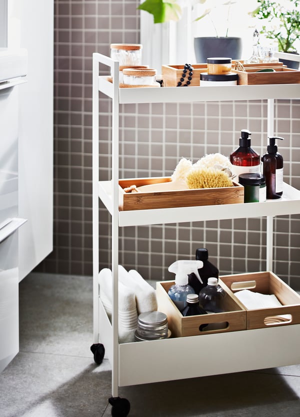 A NISSAFORS trolley in white stainless steel is filled with bath accessories.