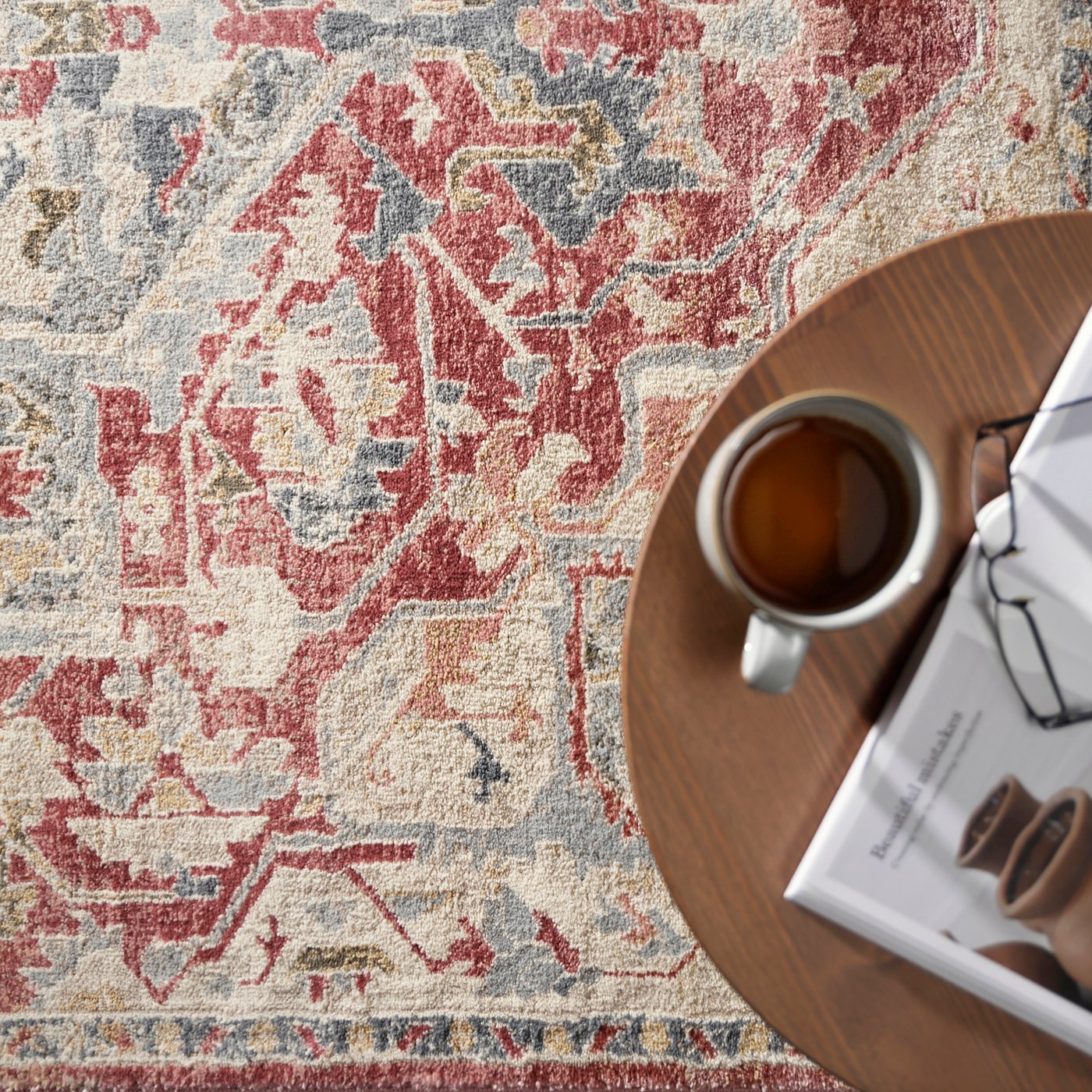 Red patterened rug with a table and coffee atop it