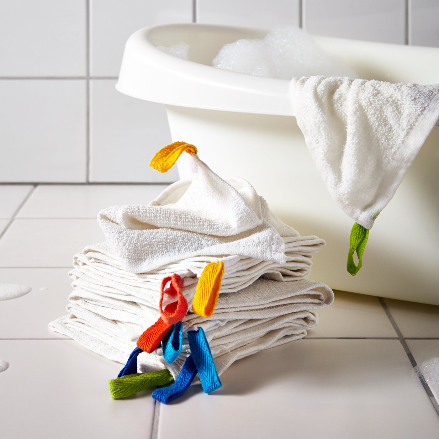 A set of ten KRAMA washclothes in white is placed next to a LÄTTSAM baby bath.