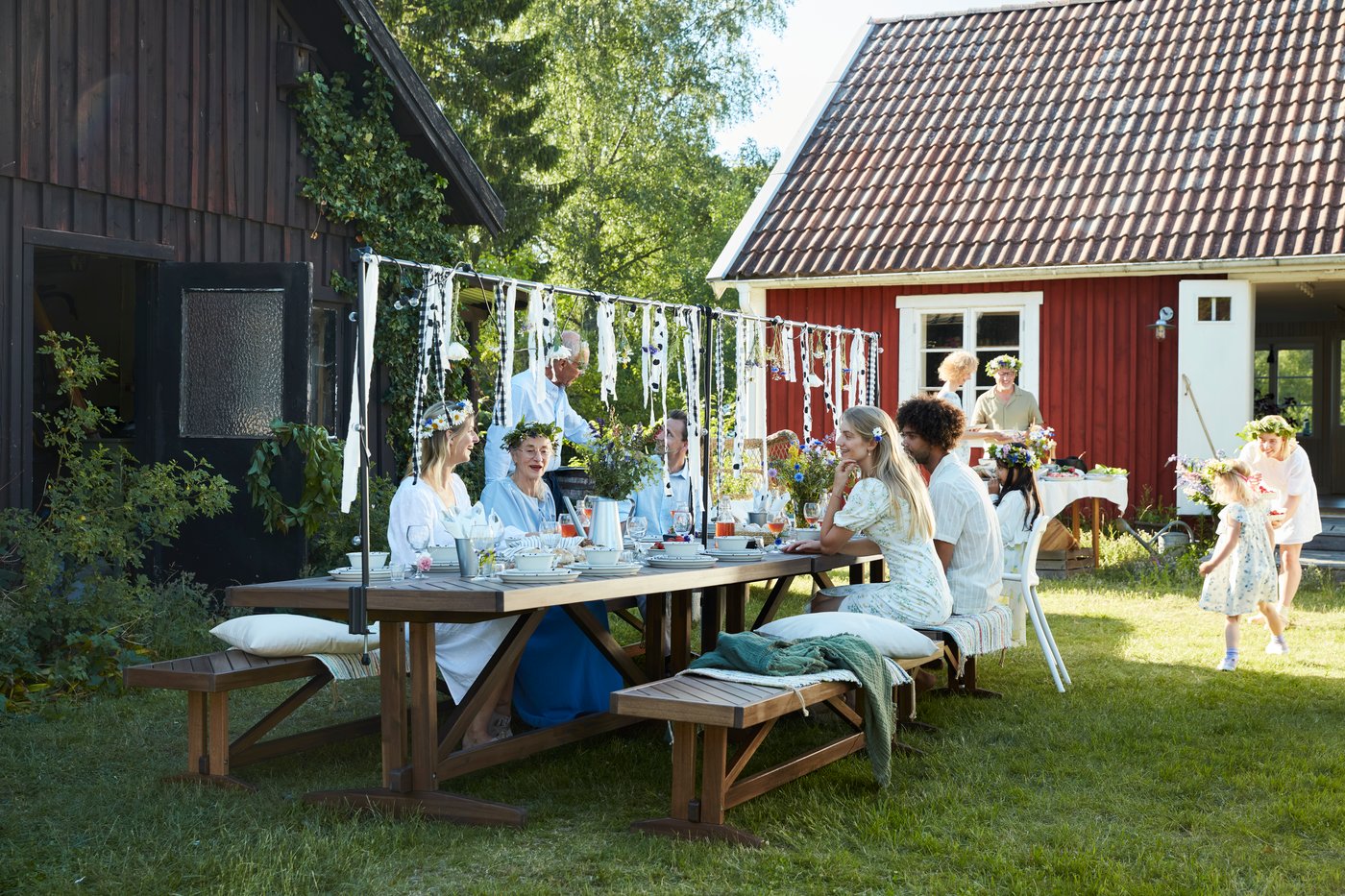 Mehrere Personen feiern gemeinsam das schwedische Midsommarfest.