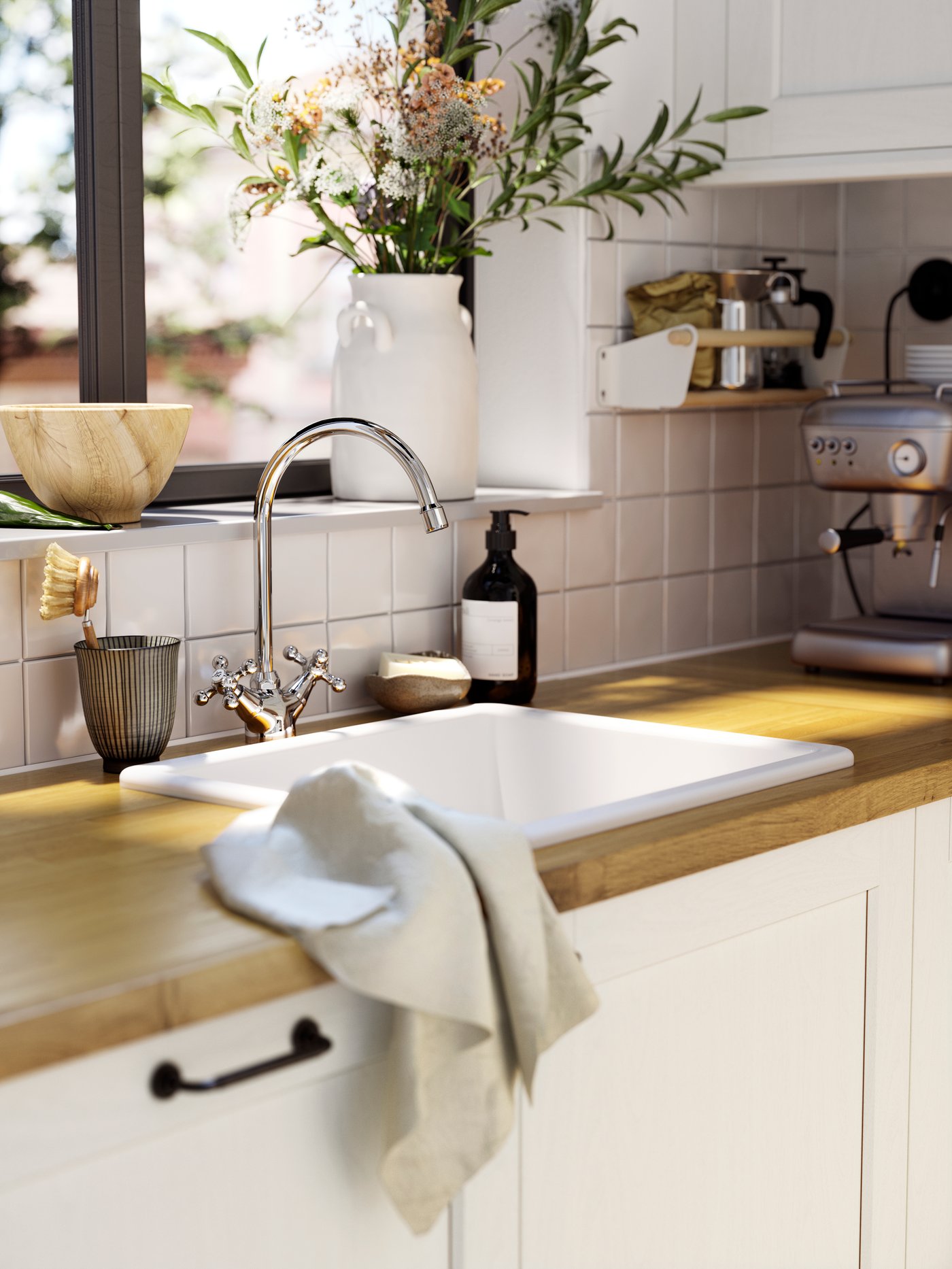 Una cocina con una cubierta de cocina KARLBY con un lavaplatos HAVSEN IKEA. Sobre la cubierta hay un paño de cocina blanco. 