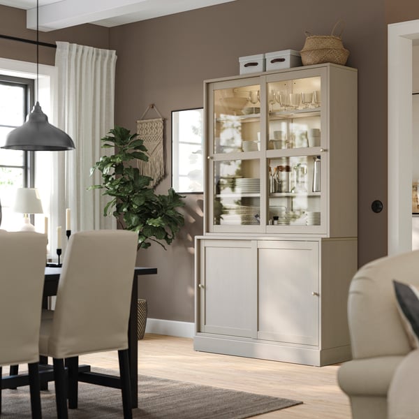 A grey-beige HAVSTA storage comb w sliding glass doors in the dining room.