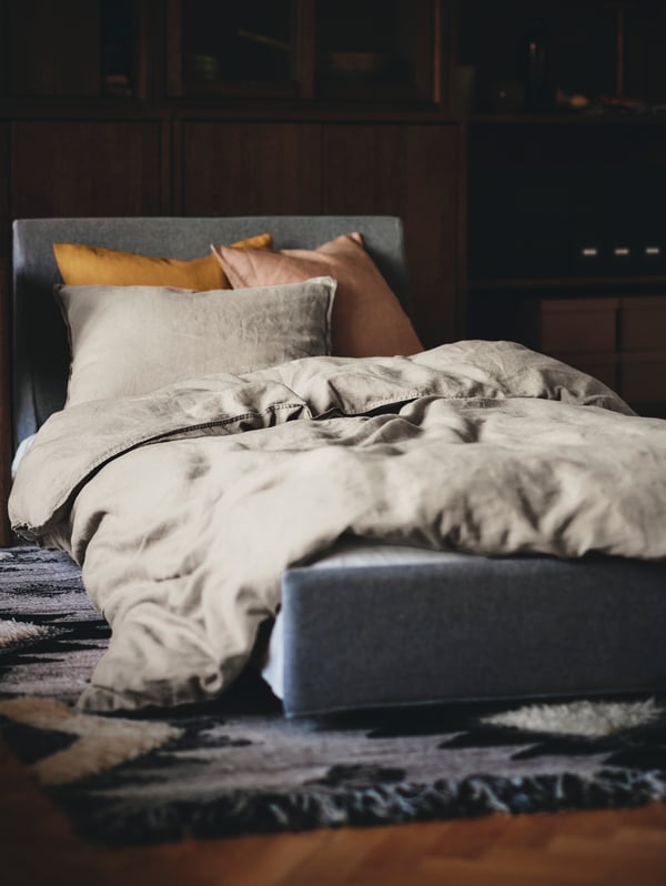 A cosy bed with cuddly natural-coloured bed linen from our ÄNGSLILJA series.