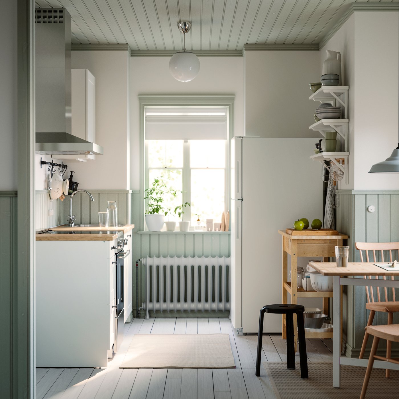 A small and bright kitchen with a window has white KNOXHULT cabinets, a dining table, and a rug on the floor.