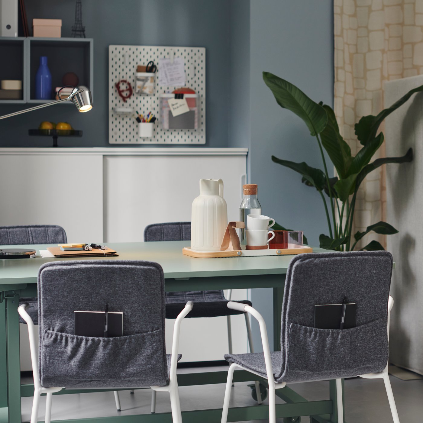 LÄKTARE conference chairs are placed around a MITTZON foldable table with castors in an office space with blue walls.