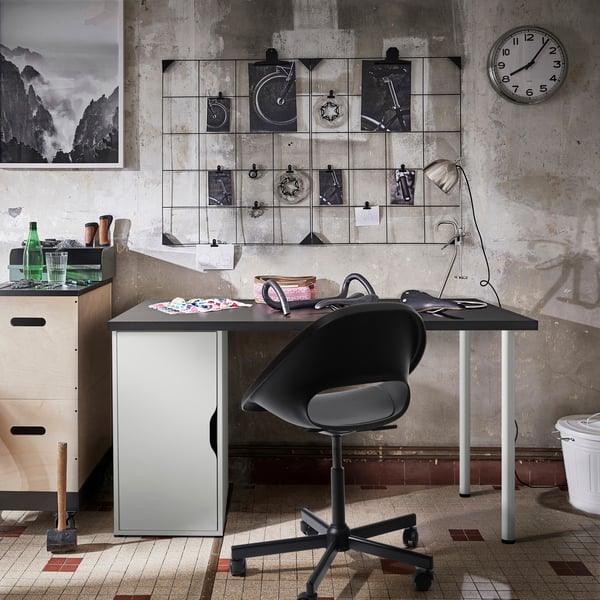 Una habitación con un escritorio, silla de escritorio y panel de pared.