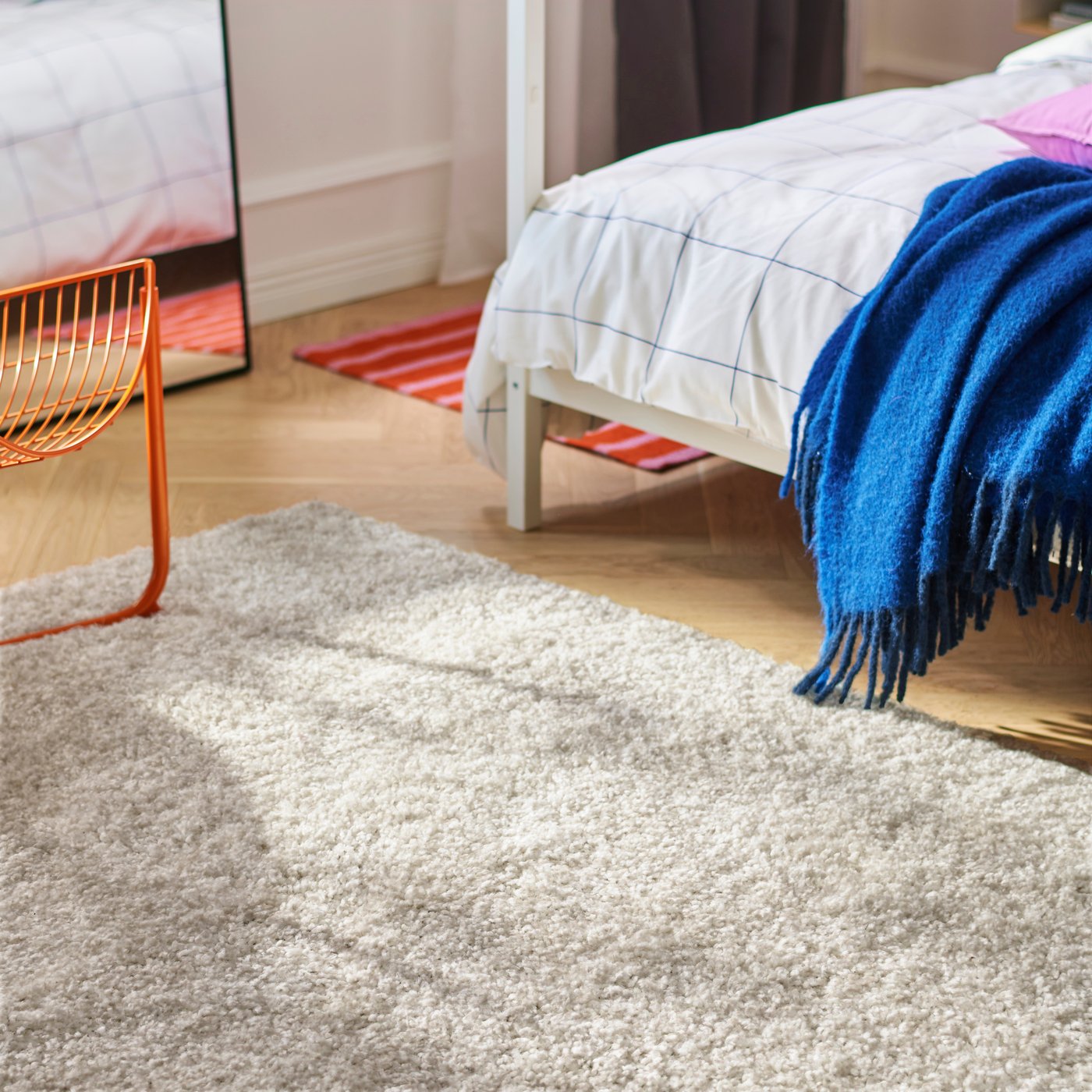 An off-white ÄRENDE rug, high pile in the bedroom