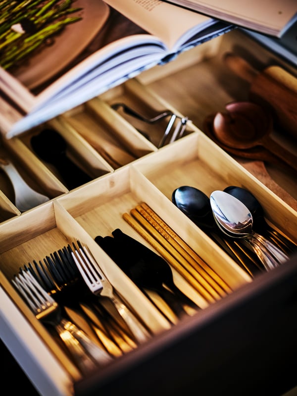 A black TILLAGD 24-piece cutlery set in the kitchen