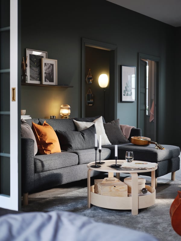 A green living room with a dark-grey PÄRUP three-seat sofa with chaise longue, and a BORGEBY birch coffee table.