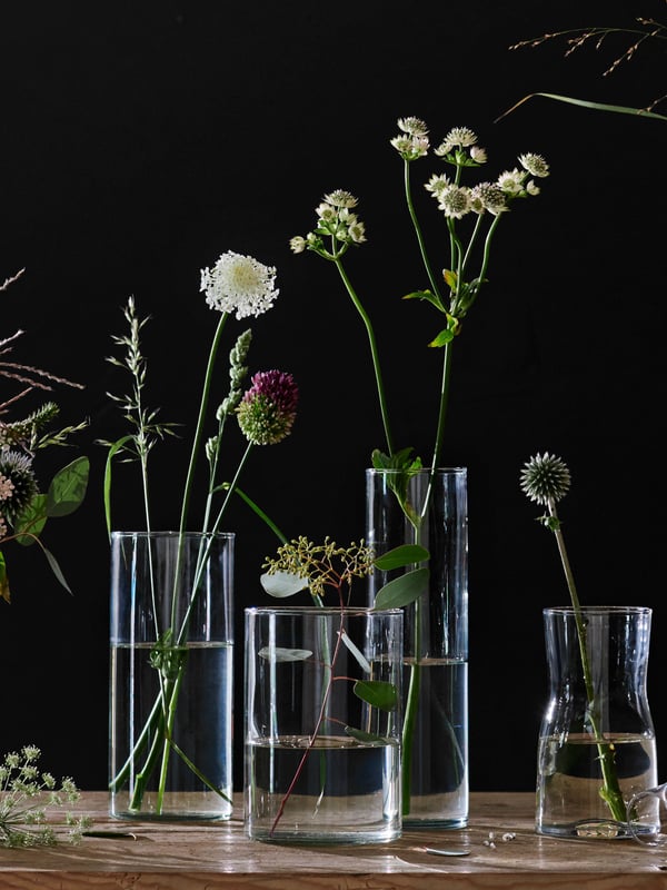 Fyra cylindervaser i olika höjder och bredder, även en smal vas för en blomma. 