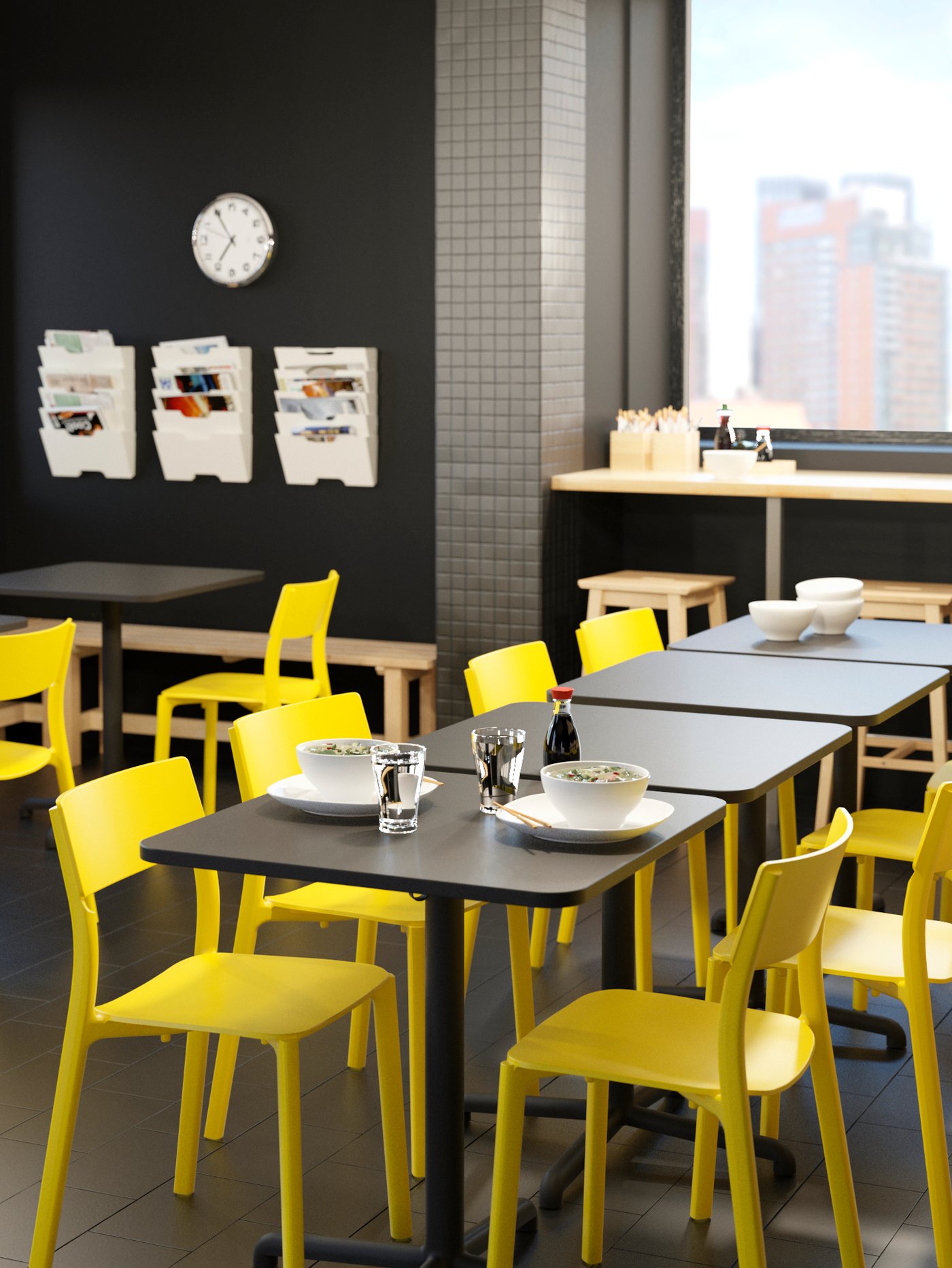 Una cafetería con mesas de cafetería IKEA y sillas plásticas amarillas.