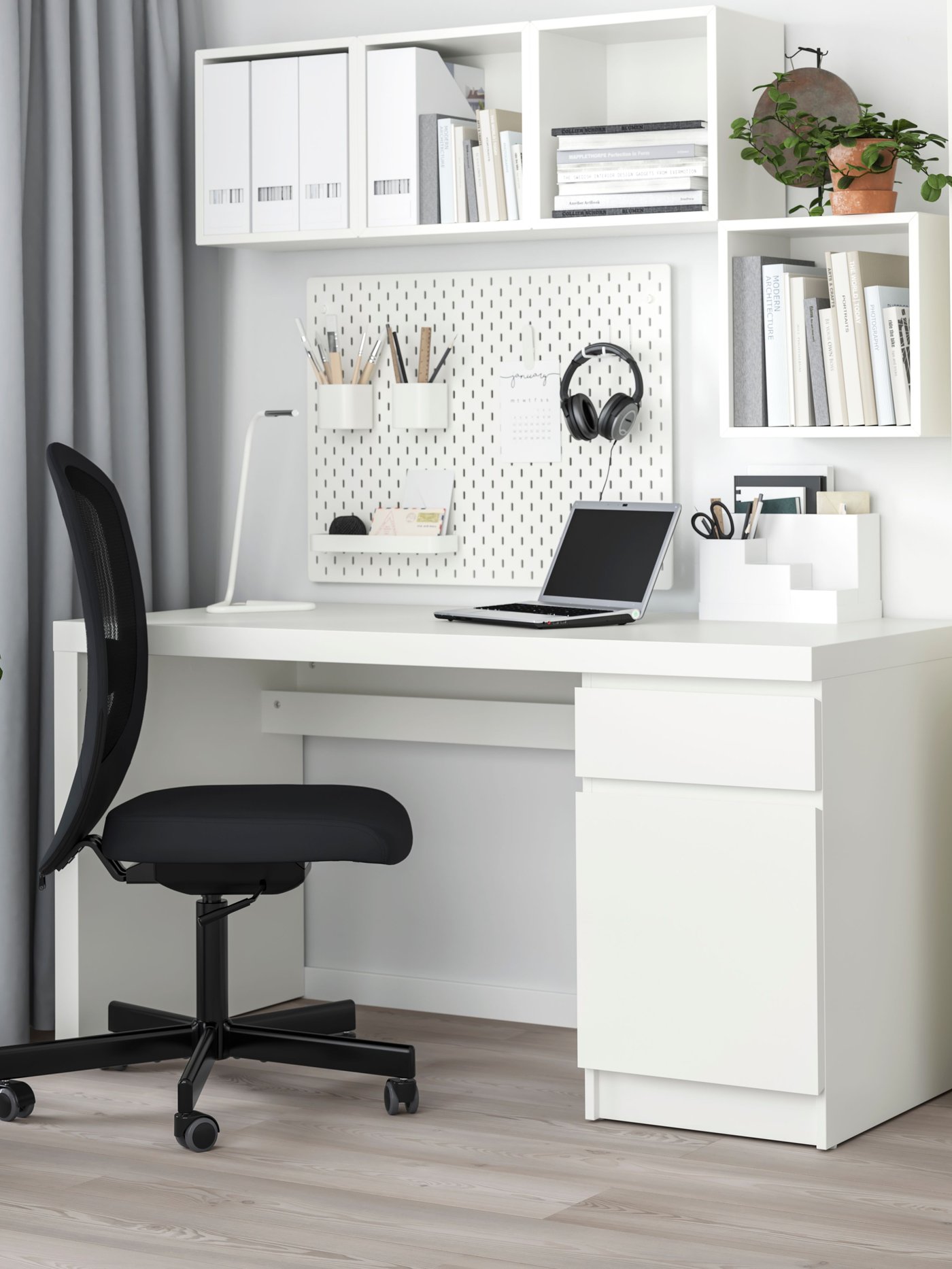 A white MALM desk with a black desk chair in a home office.