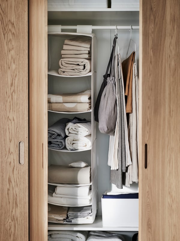 A white/oak veneer PAX wardrobe combination in the bedroom