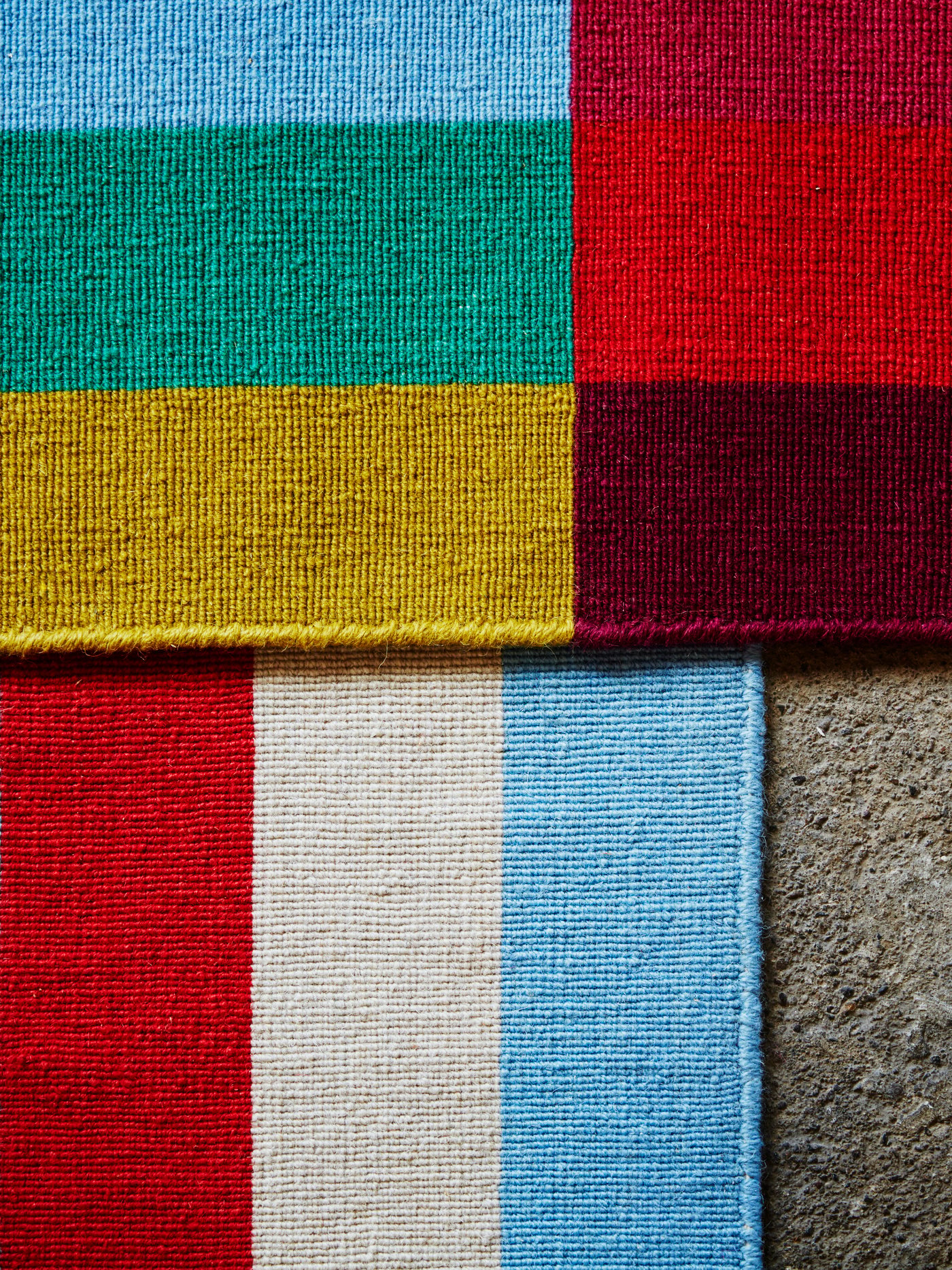 Tapete HALVED tejido a mano en varios colores y de tejido plano, en un espacio interior.