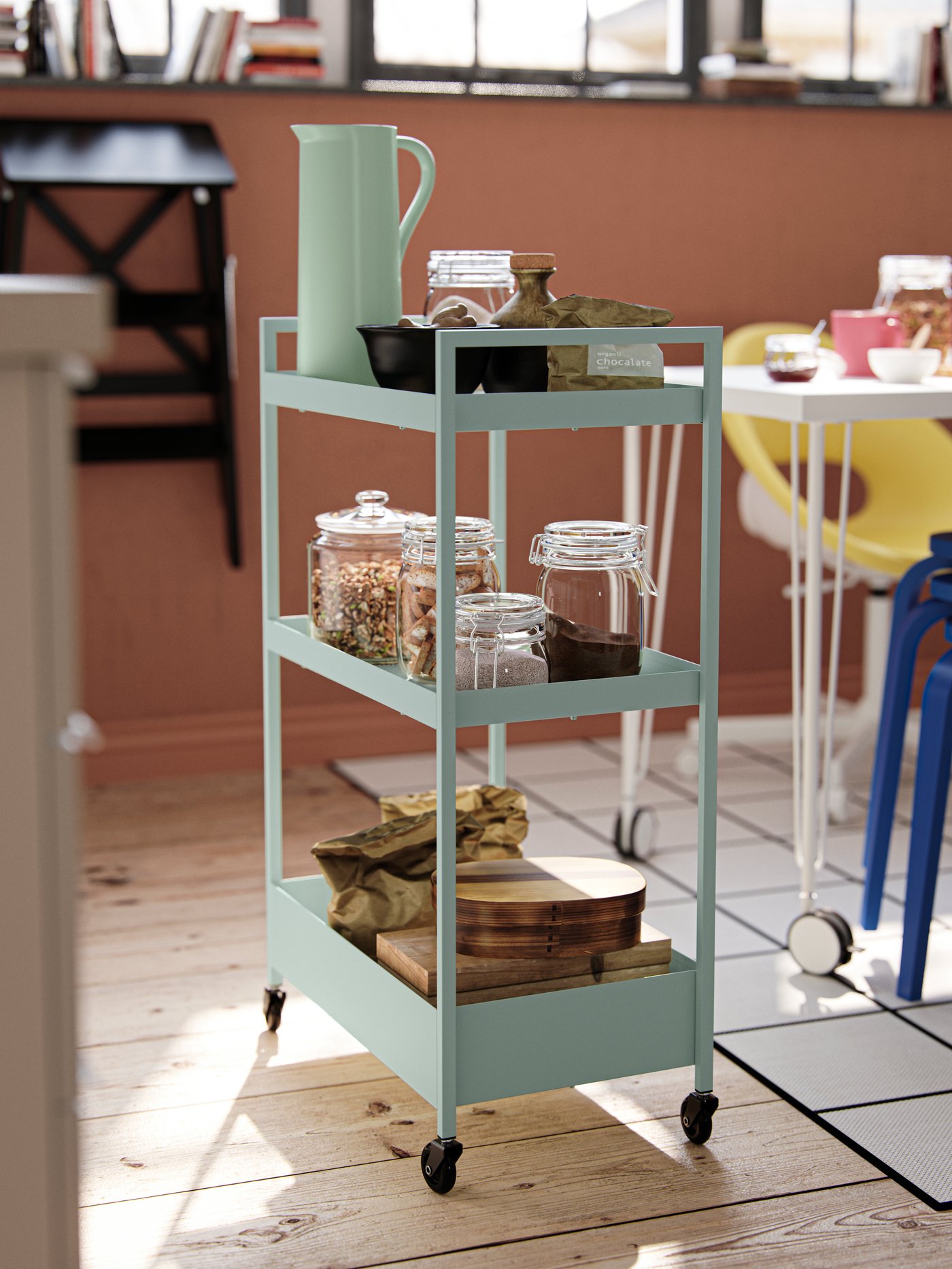 A green NISSAFORS kitchen trolley is filled with jars, drinking utensils and other accessories.