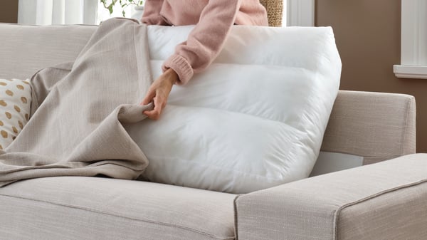 A woman changes the sofa cover on her KIVIK sofa.