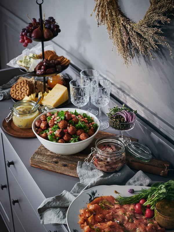 Serveware, jars and bowls filled with different foods, placed on a grey HAUGA sideboard as a self-serve buffet.