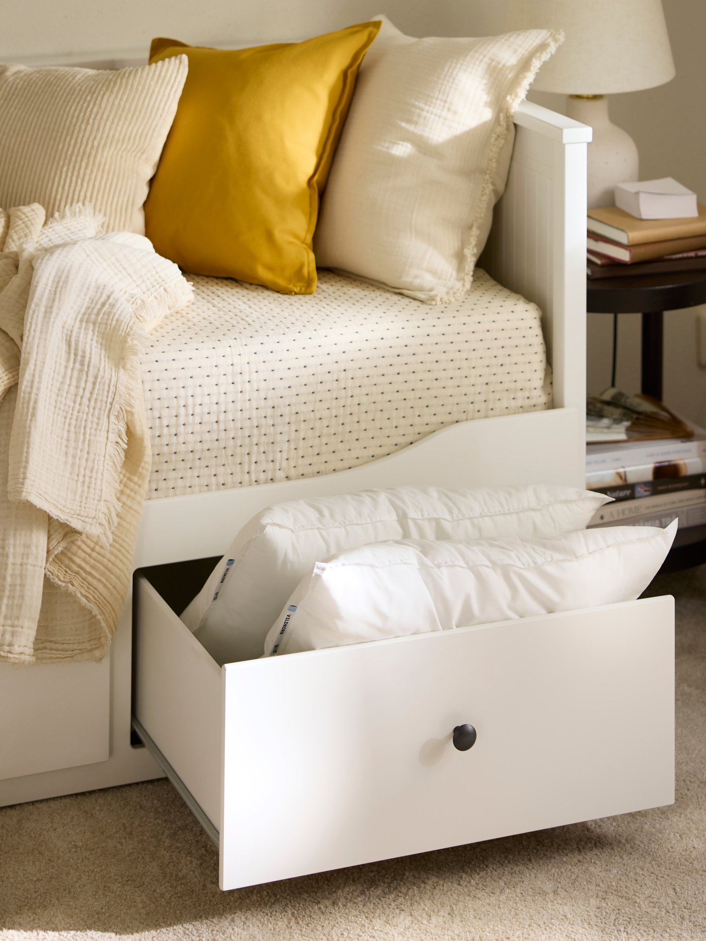 Close-up of one of the drawers on HEMNES day-bed, pulled out and stuffed with extra pillows.
