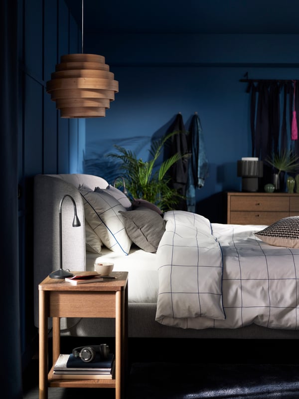 Una mesita de noche TONSTAD color roble teñido en un dormitorio
