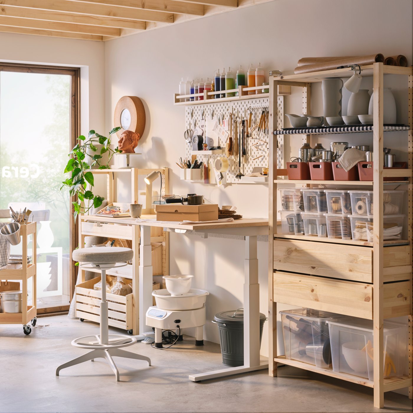 The back office of a shop with a well-organised storage and workstation including an IVAR shelving unit, a MITTZON desk and a BEKVÄM spice rack.