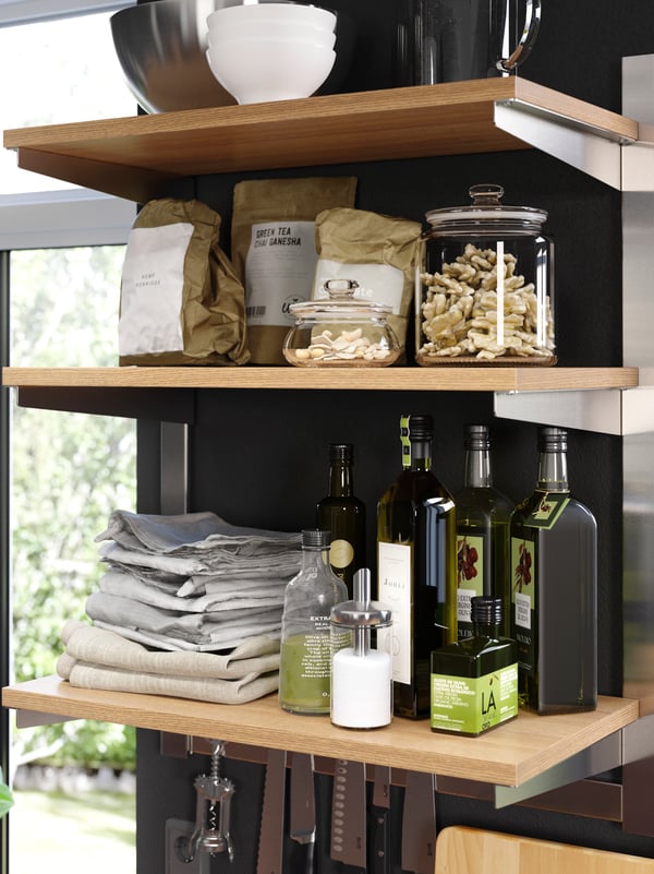 Stainless steel KUNGSFORS suspension rail with a shelf and wall grid holding glass jars with lids and white VARIERA boxes.