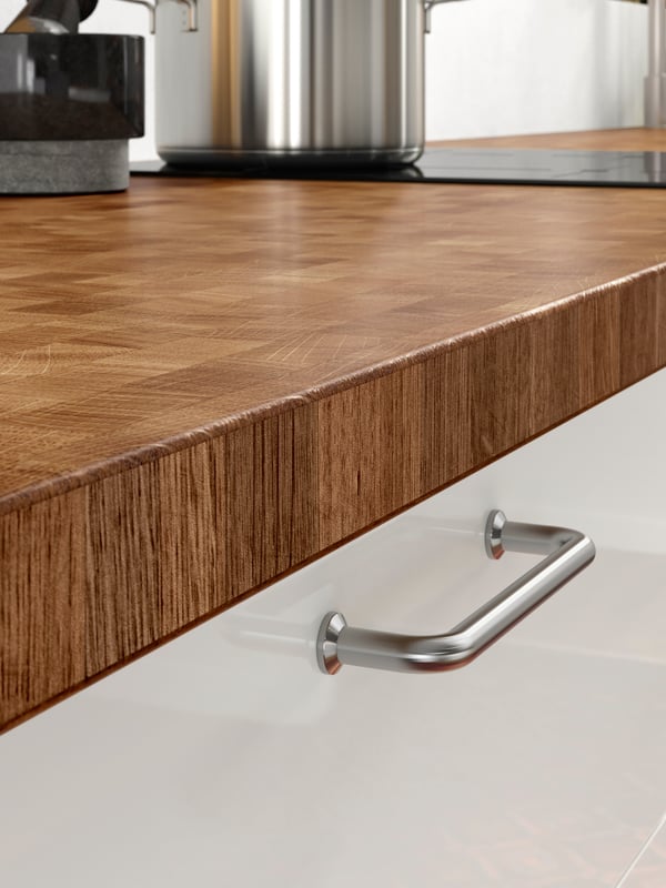A close-up of the durable SKOGSÅ worktop in oak in a kitchen setting.