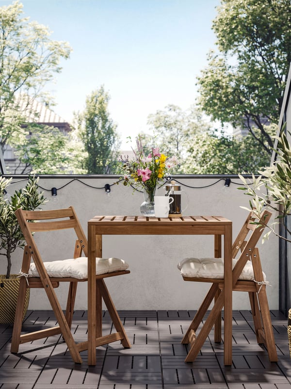 A light brown stained/Kuddarna light grey-beige NÄMMARÖ table and 2 folding chairs, outdoor outside