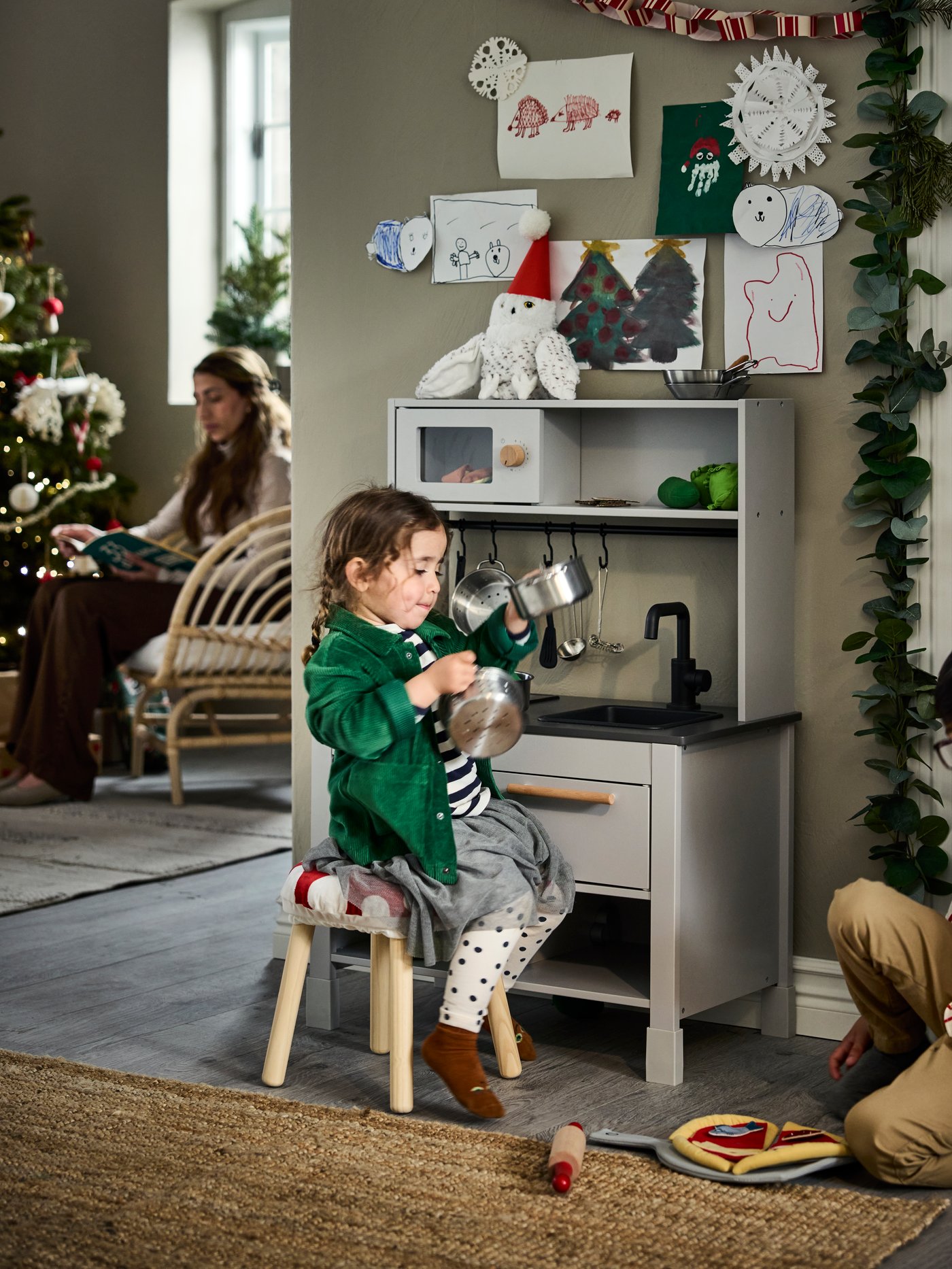 En pige leger med et legekøkken i en stue med et SILLTRUT legekøkken ved juletid.