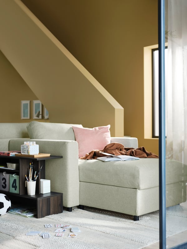 A beige VIMLE chaise longue with cushions is in the middle of a living room with yellow walls close by a staircase.