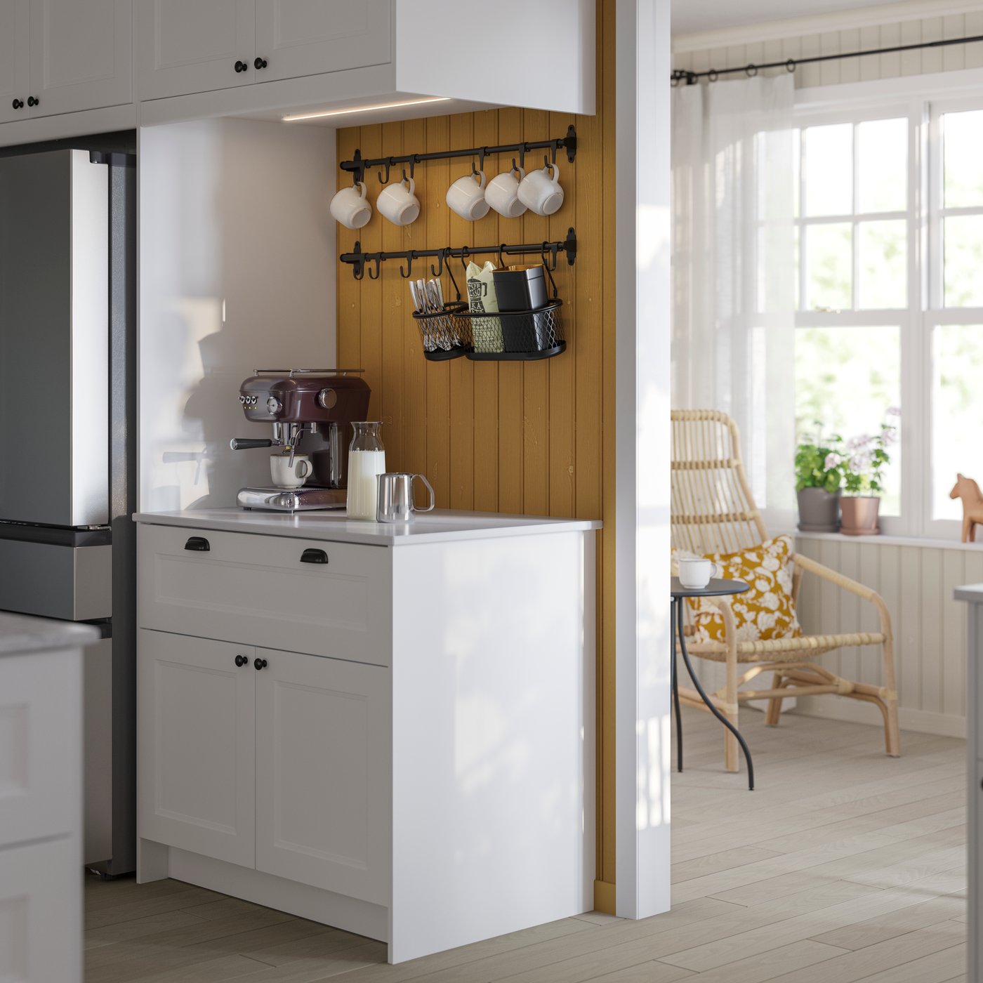 A modern kitchen with white AXSTAD fronts and kitchen utensils, combined with a stainless steel refrigerator and a HULTARP hook with coffee mugs.