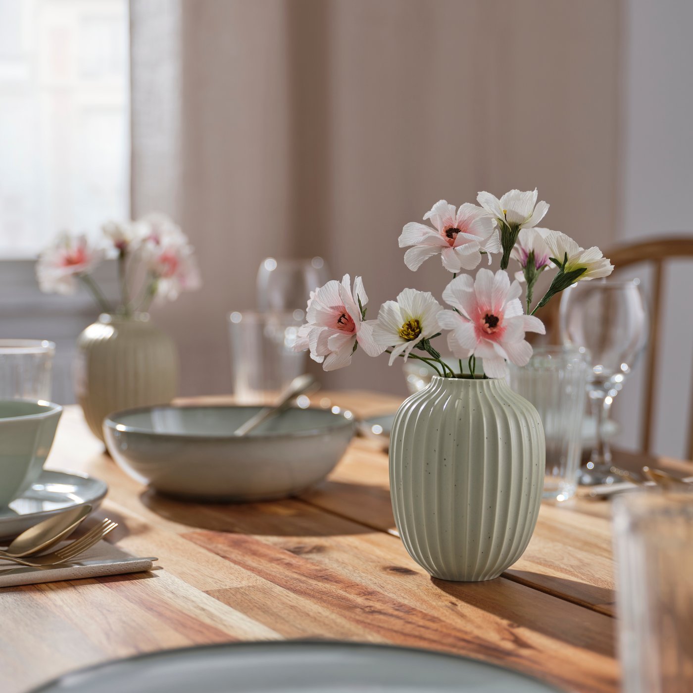 A green STJÄRNLUDD vase in the dining room