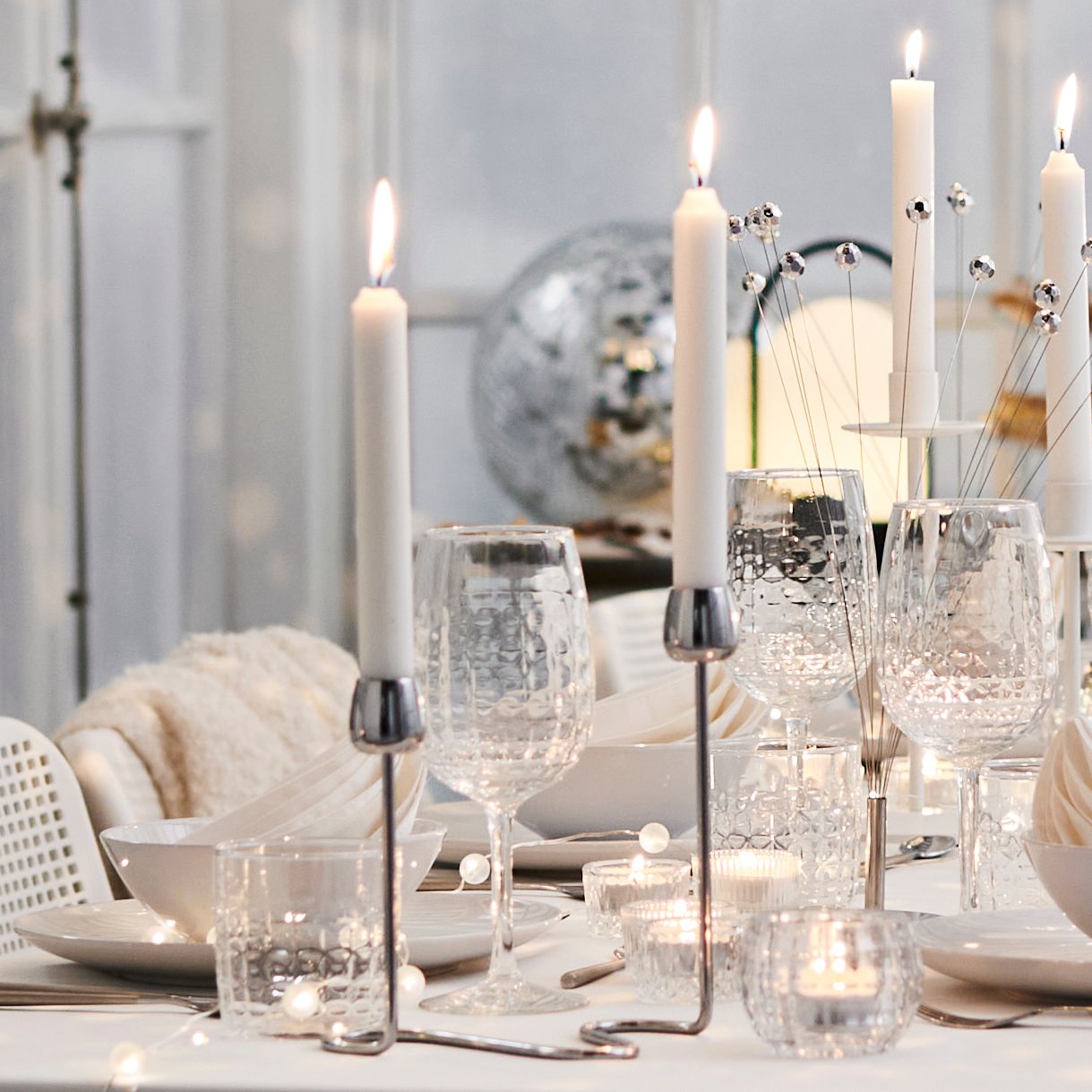 A white JUBLA unscented chandelier candle in the dining room