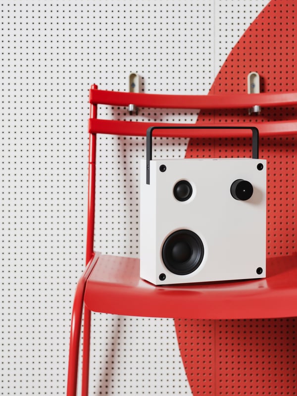 Haut-parleur bluetooth VAPPEBY blanc sur une chaise rouge.