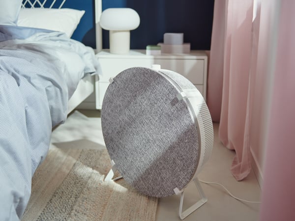 Podni IKEA STARKVIND prečišćivač vazduha pored kreveta.